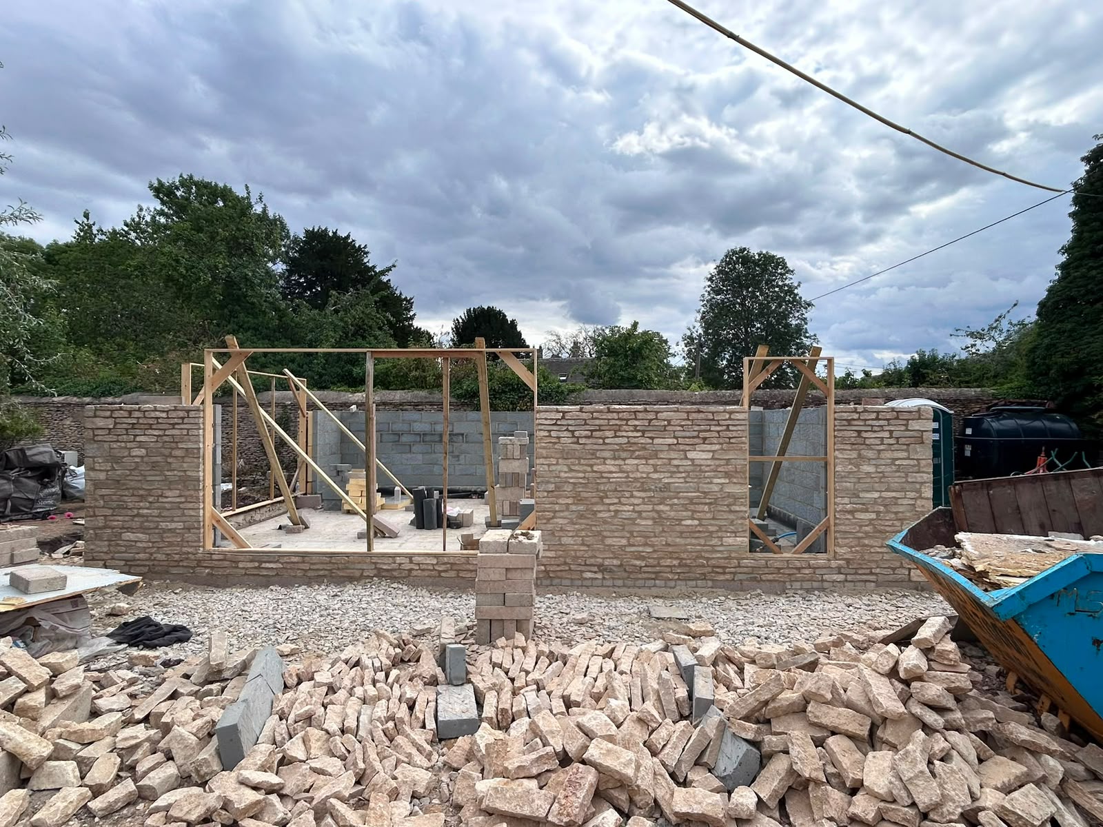 Curved Cotswold stone wall being built by DR Smith Building stone masons.