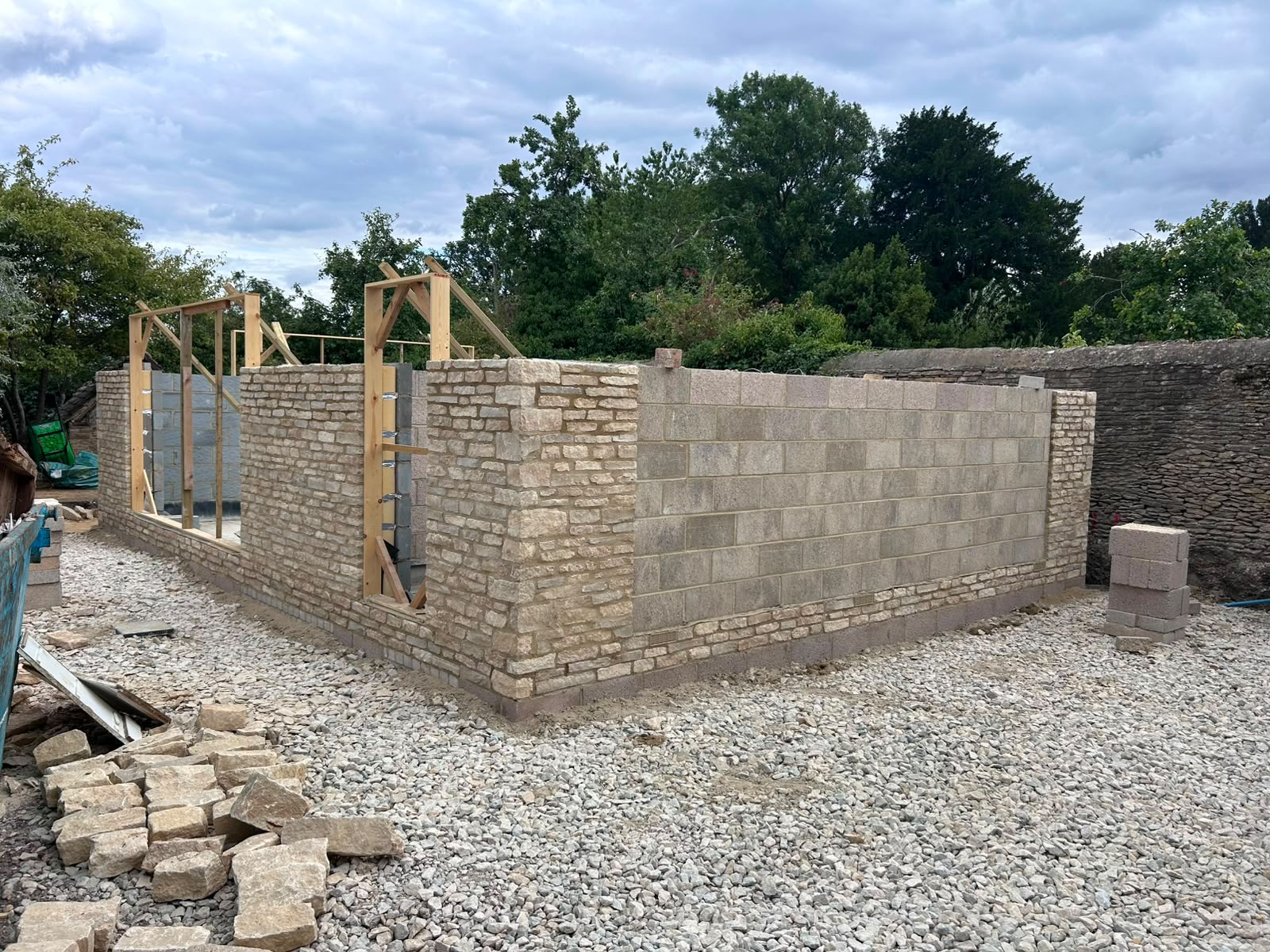 Timber-framed roof going on stone walls, in-progress build by DR Smith Building.