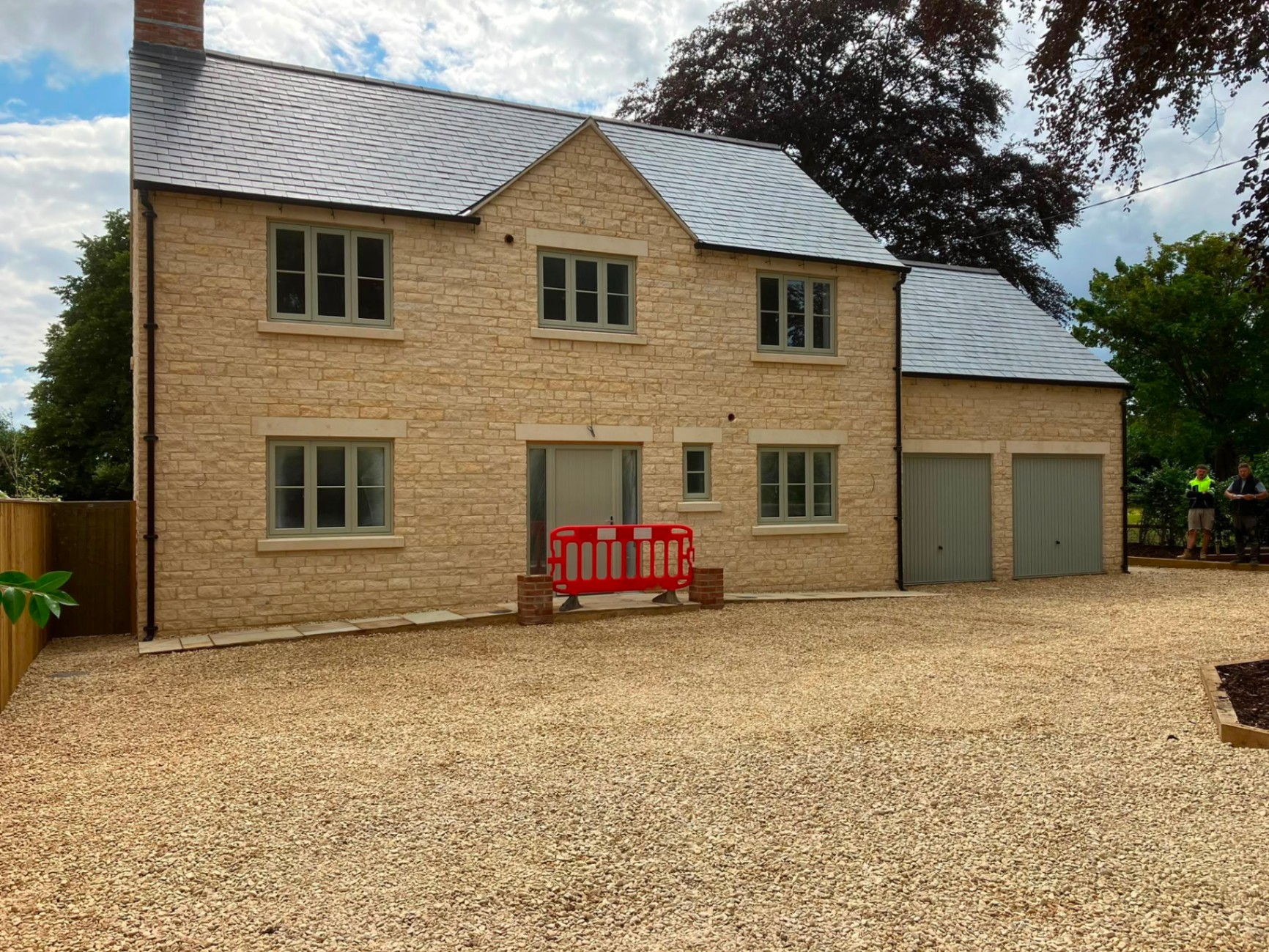 Full Cotswold stone new-build home with slate roof and dressed stone quoins, built by DR Smith Building.